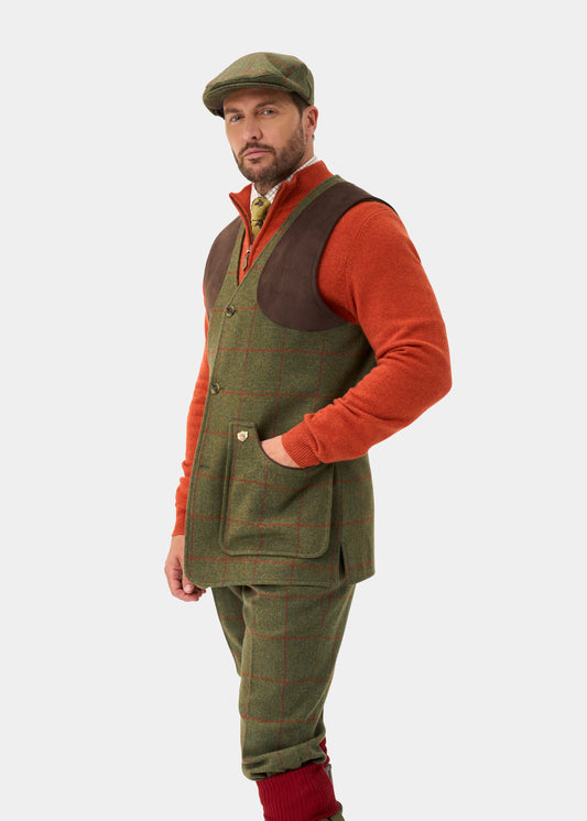 Man in a Combrook Men’s Tweed Shooting Waistcoat in Reed and shooting fit stands against a white background.