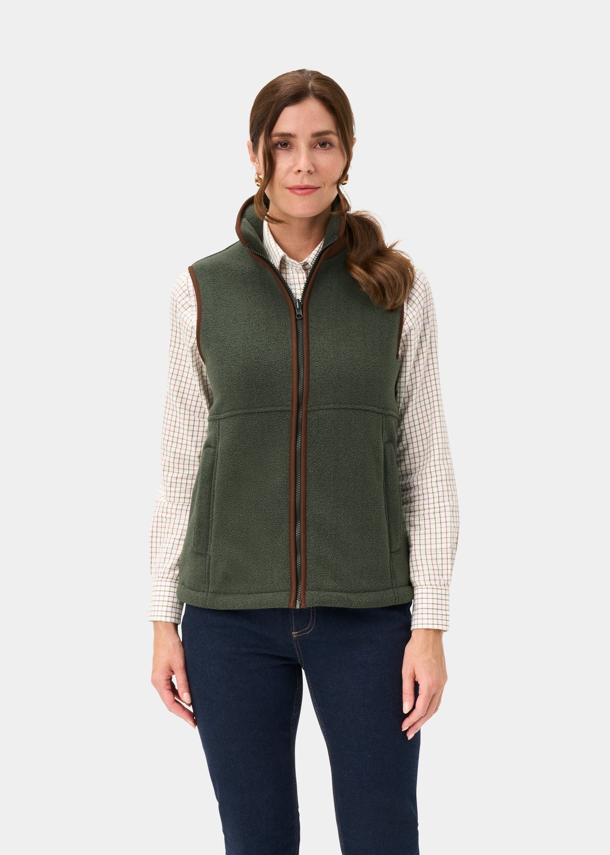 Woman in Aylsham Ladies Cedar Green fleece gilet, over plaid shirt and dark jeans, against a plain light background.