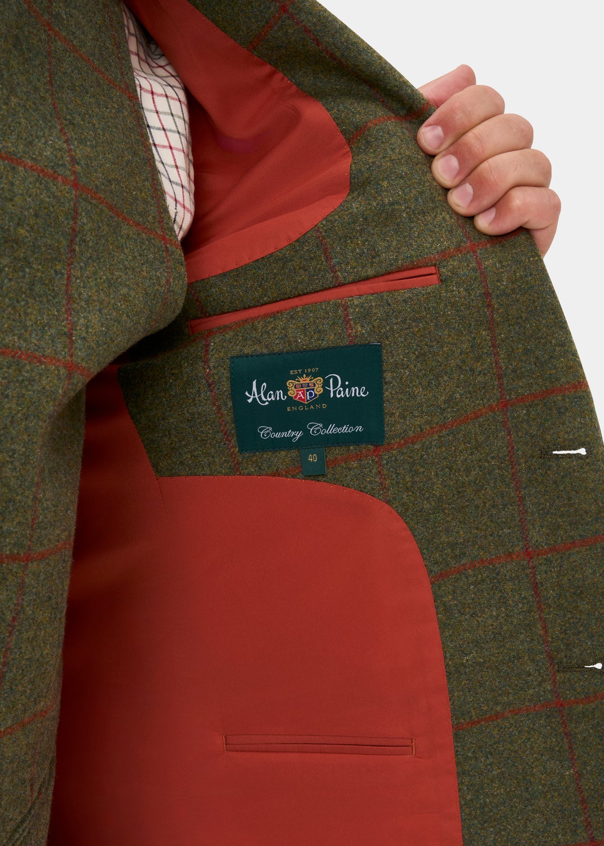 Person opens a green Combrook Men’s Tweed Water Repellent Sports Blazer in Reed, showing the Alan Paine label inside.