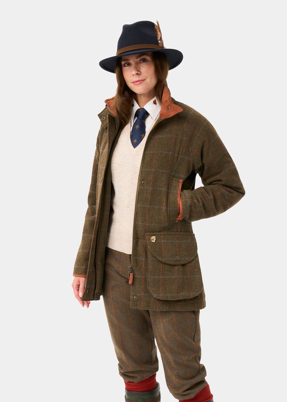 Woman in Combrook Ladies Tweed Waterproof Shooting Coat in Willow poses against a plain light background.