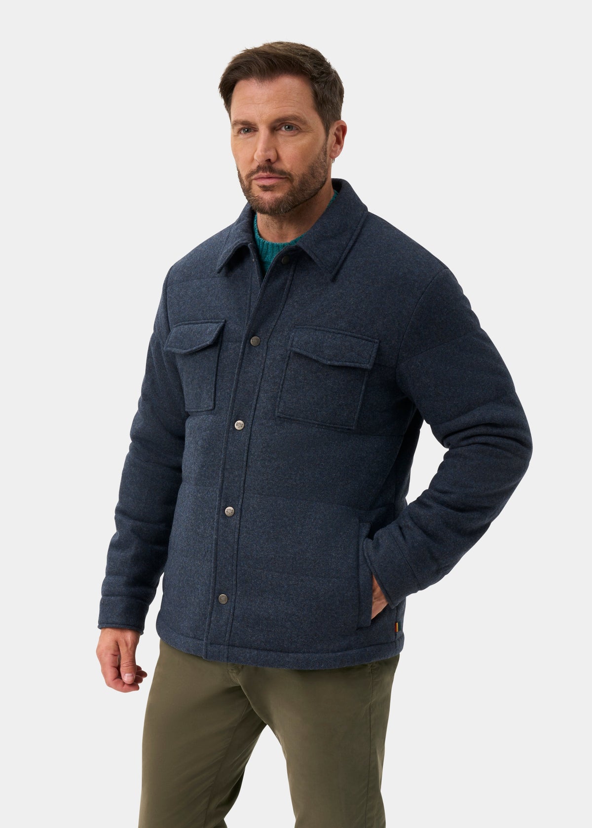 A man wearing a Richmond Men’s Knitted Quilted Shacket In Navy over a green sweater and olive trousers.