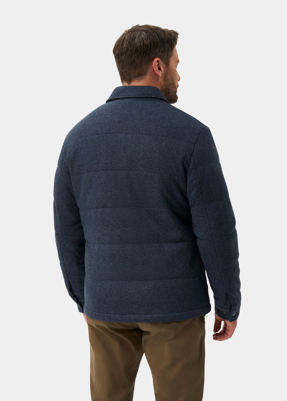 A man seen from behind wearing a Richmond Men’s Knitted Quilted Shacket In Navy over brown trousers.