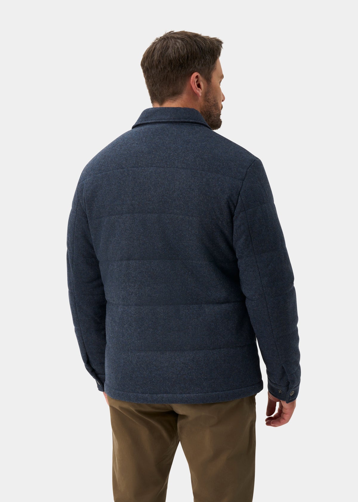 A man seen from behind wearing a Richmond Men’s Knitted Quilted Shacket In Navy over brown trousers.