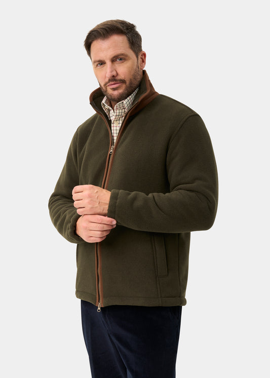 Man in Aylsham Men’s Fleece Windblock in green over plaid shirt, standing against a plain light background.