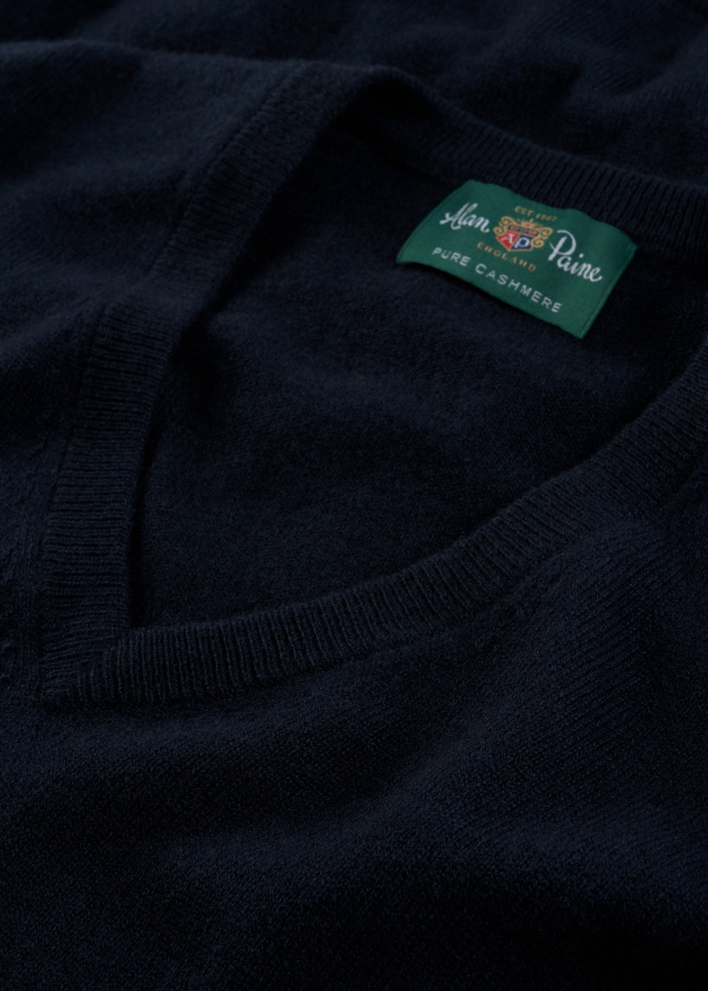 Close-up of Haddington Pure Cashmere V-Neck Jumper in Dark Navy, Regular Fit, showing Alan Paine label.