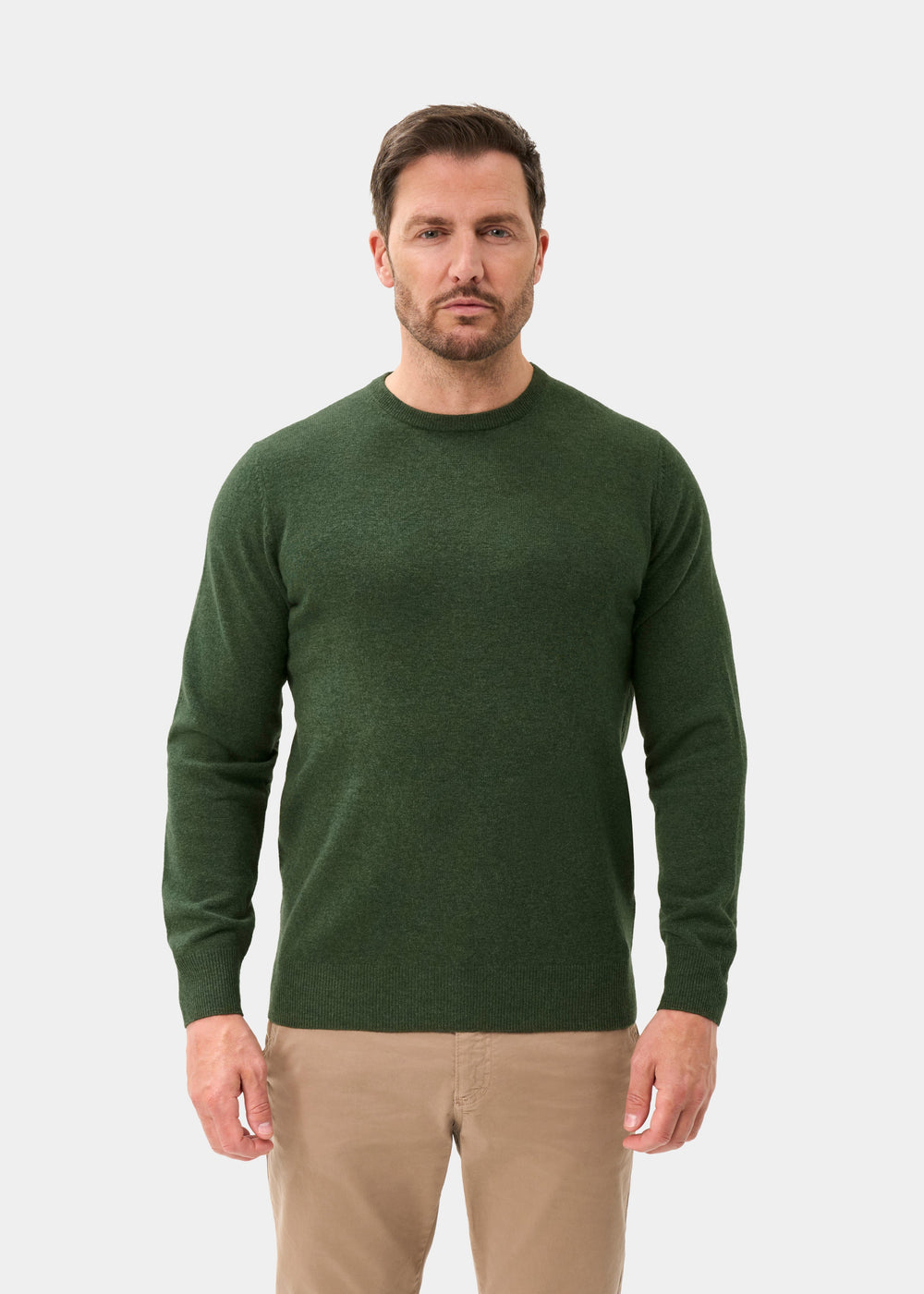 Man wears a rosemary Brisbane Geelong wool crew neck jumper and beige pants, facing forward against a white background.
