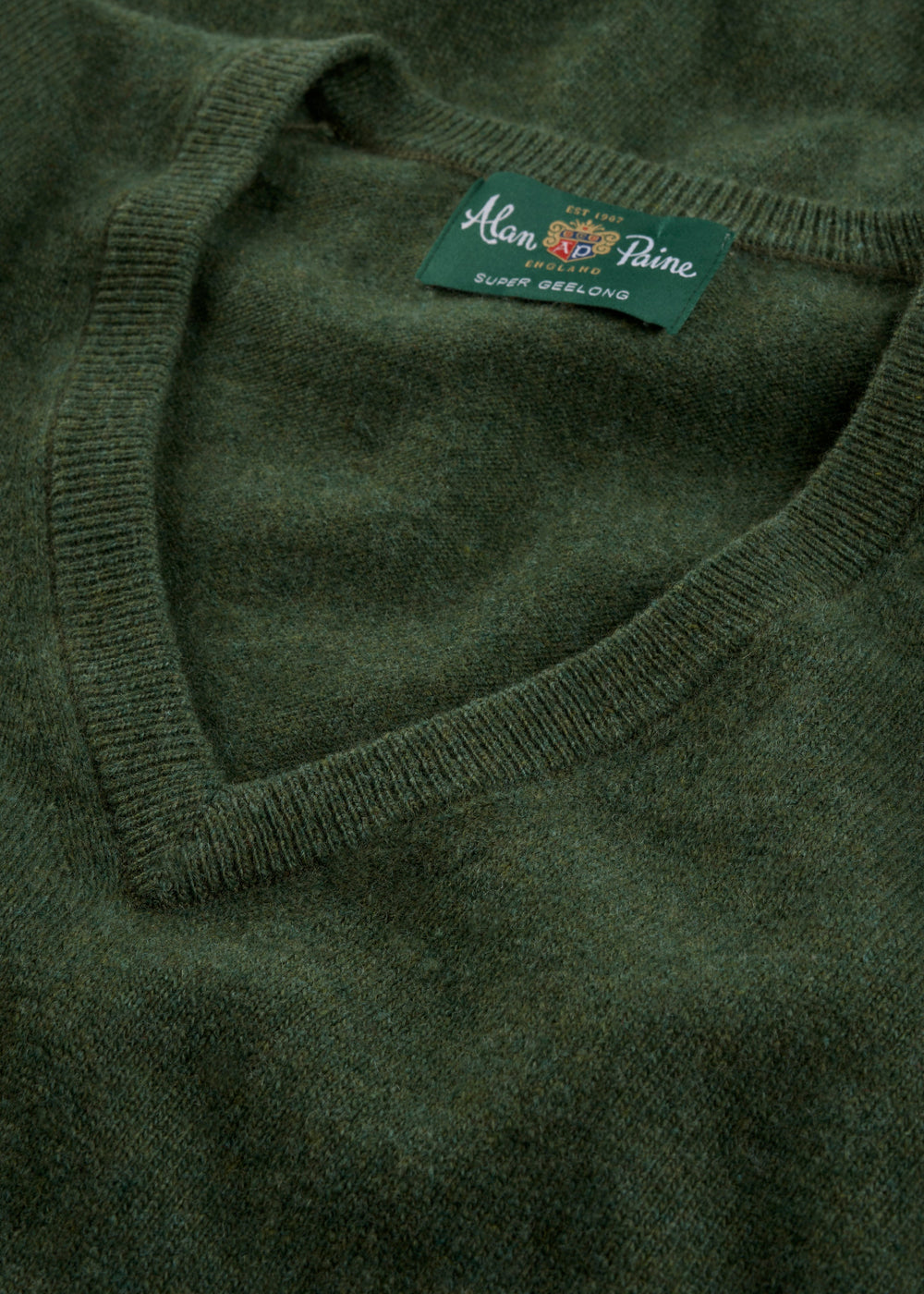 Close-up of the Albury Geelong Wool V-Neck Jumper in Rosemary, regular fit, with inner label visible.