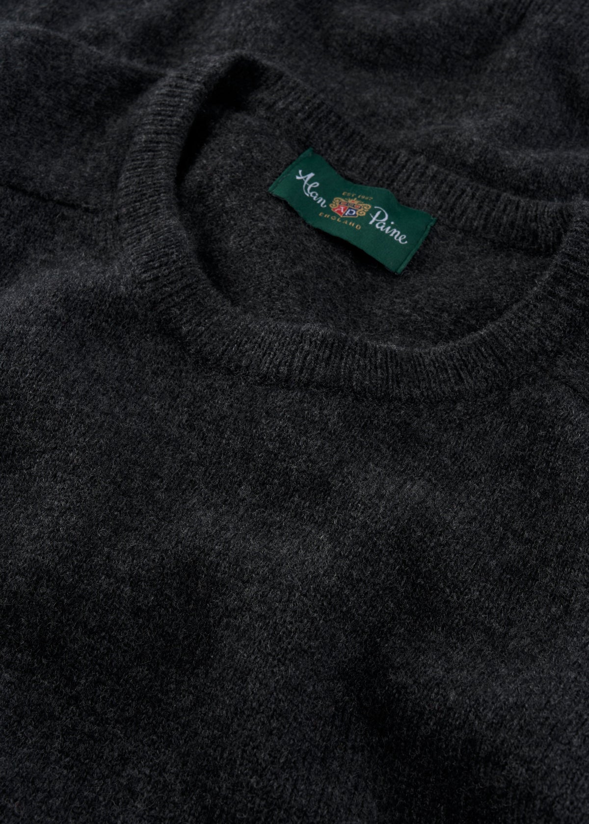 Close-up of Dorset Lambswool Crew Neck Jumper in Charcoal - Classic Fit, label visible at the neckline.