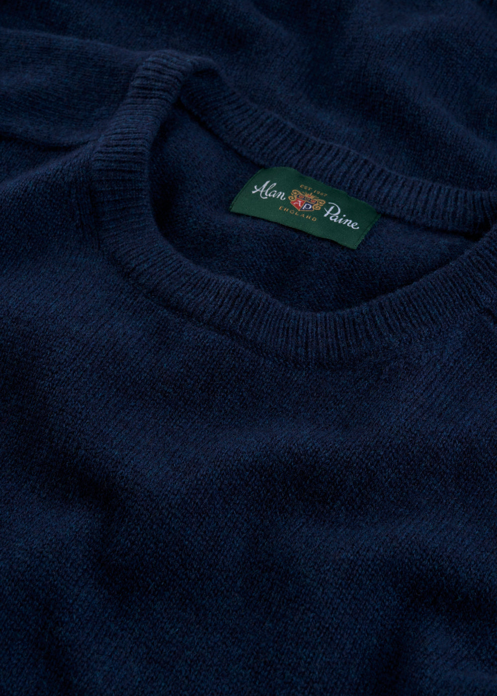 Close-up of Dorset Lambswool Crew Neck Jumper in Indigo, classic fit, showing collar and Alan Paine label.