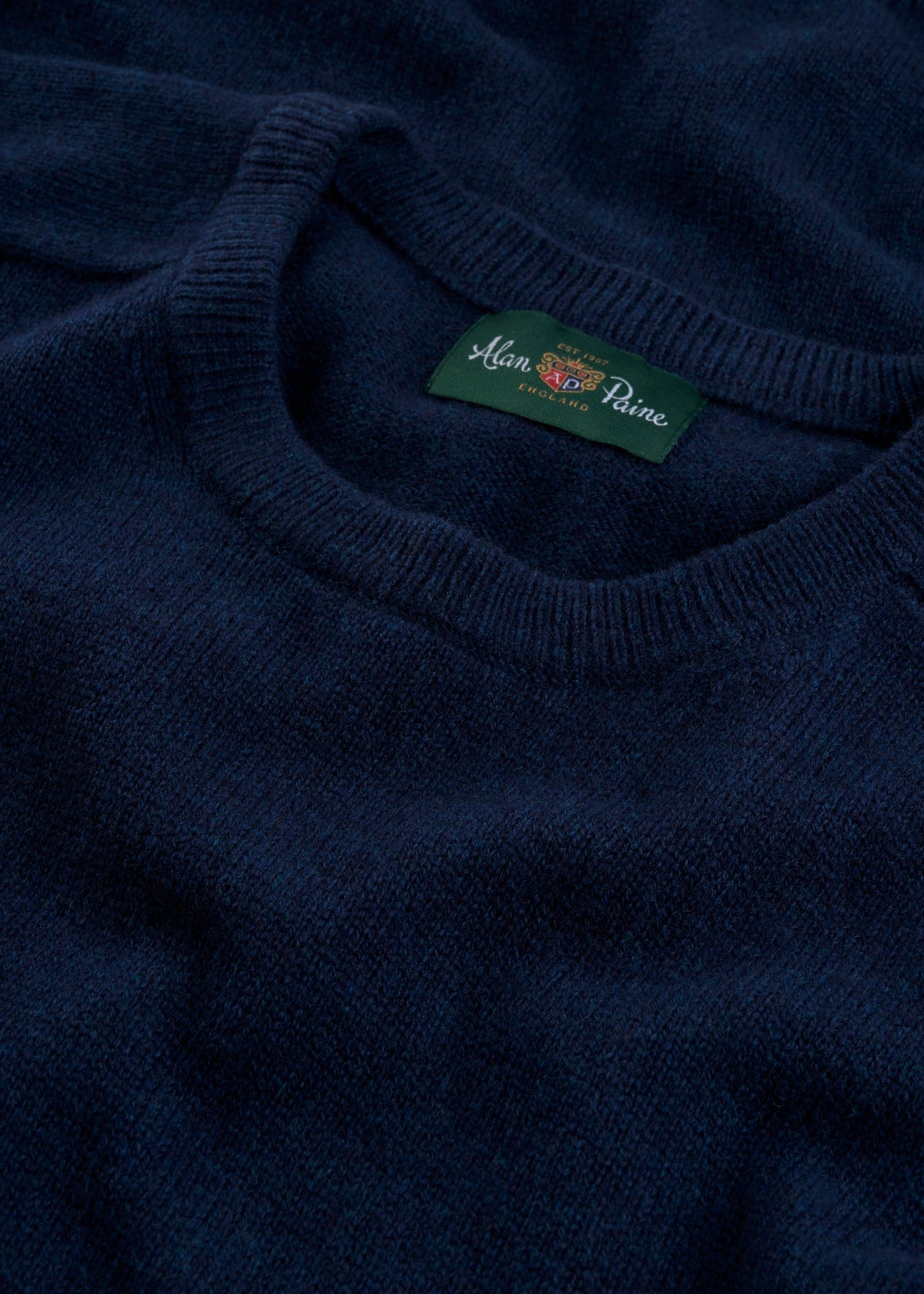 Close-up of Dorset Lambswool Crew Neck Jumper in Indigo, classic fit, showing collar and Alan Paine label.