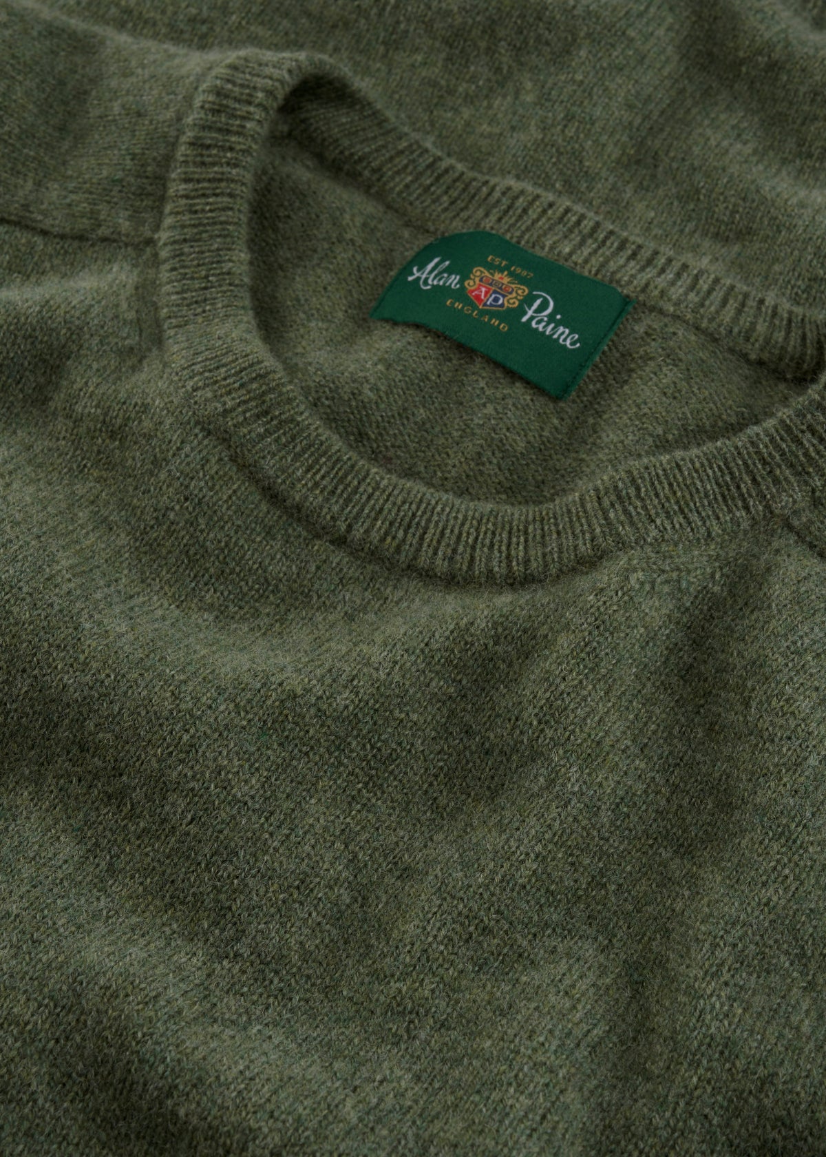 A close-up of the Lenzie Lambswool Crew Neck Jumper in Landscape, featuring an inside collar Alan Paine England label.