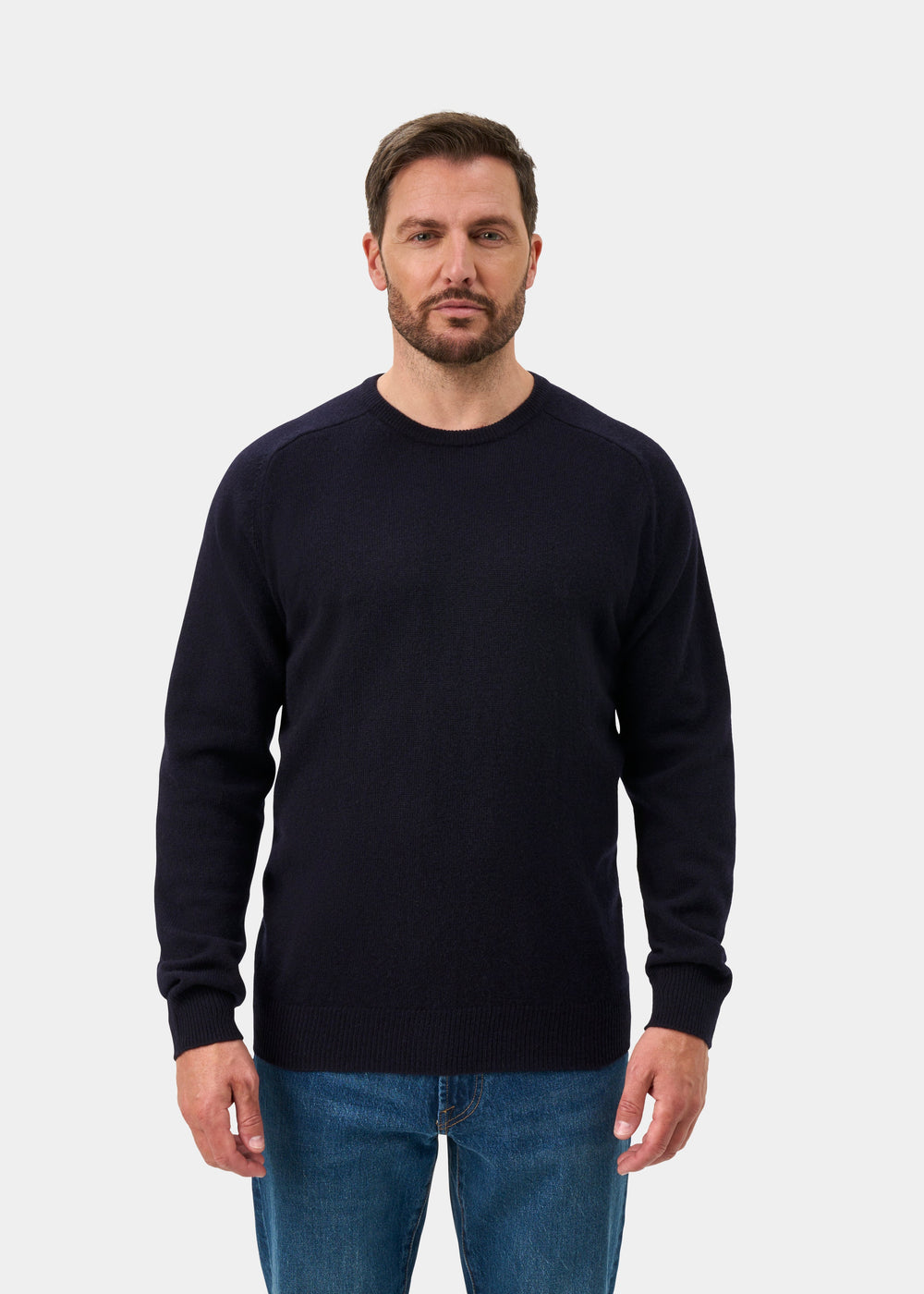 Man with brown hair and beard in Dorset Lambswool Crew Neck Jumper in Navy, classic fit, against plain background.