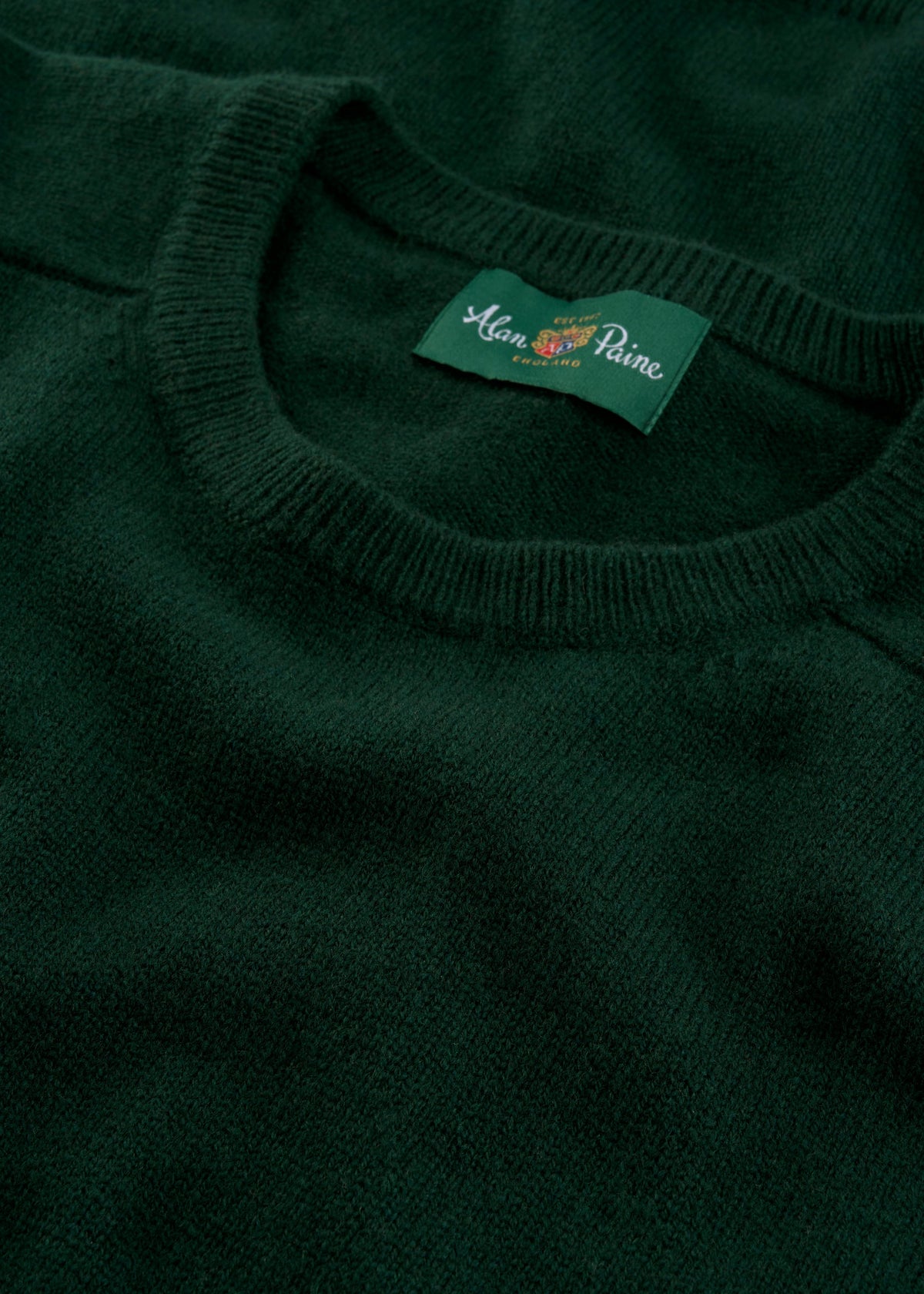 Close-up of Lenzie Lambswool Crew Neck Jumper in Tartan Green - Regular Fit, Alan Paine label on collar.
