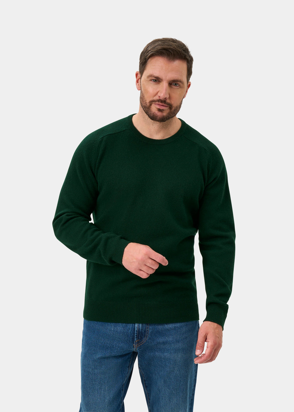 Model wears Dorset Lambswool Crew Neck Jumper in Tartan Green, classic fit, styled with blue jeans against a white backdrop.