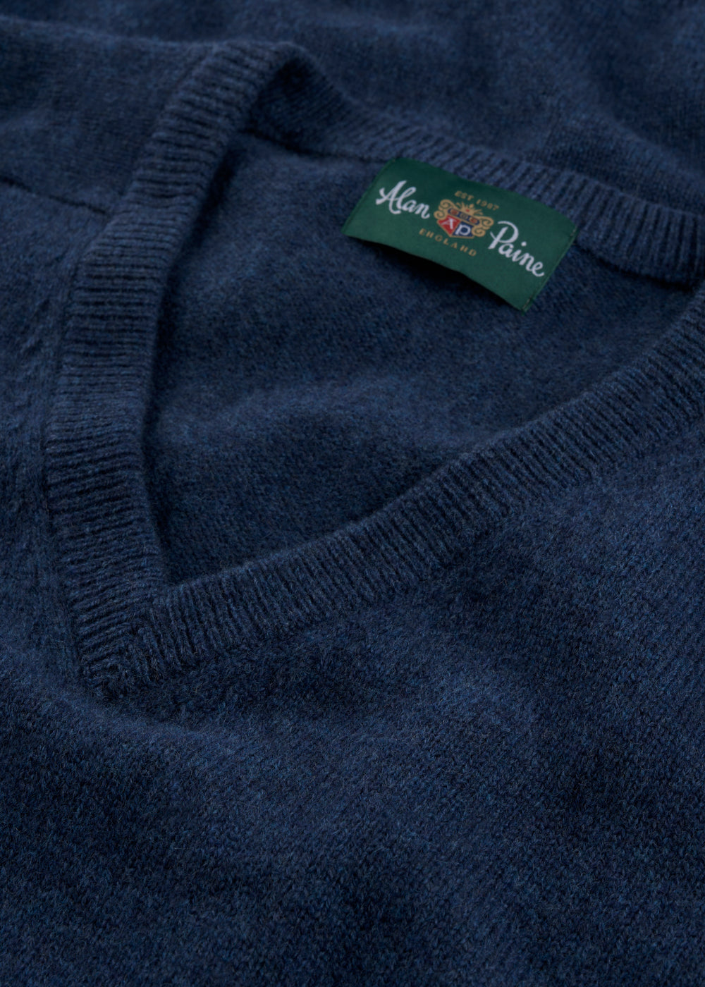 Close-up of Kilsyth Lambswool Vee Neck Jumper in Jeans, Regular Fit, with Alan Paine England label on the collar.