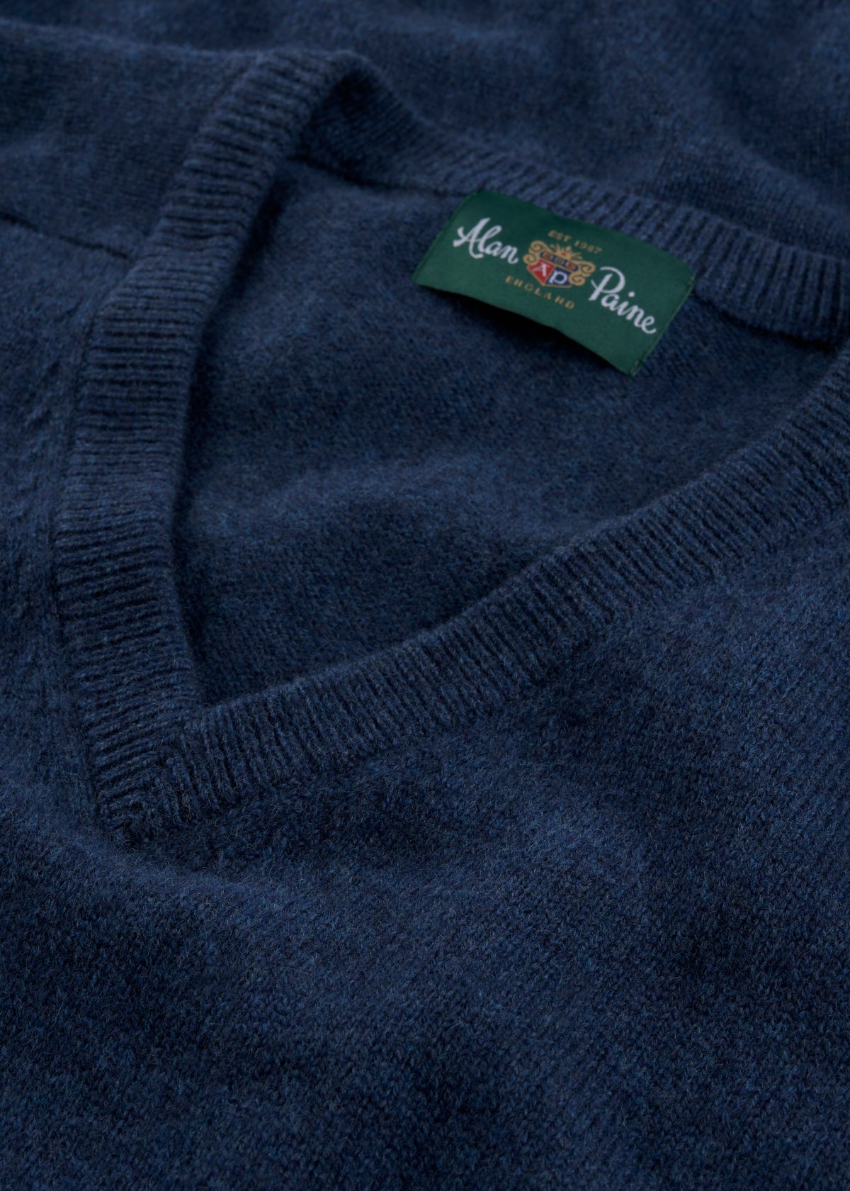 Close-up of Kilsyth Lambswool Vee Neck Jumper in Jeans, Regular Fit, with Alan Paine England label on the collar.
