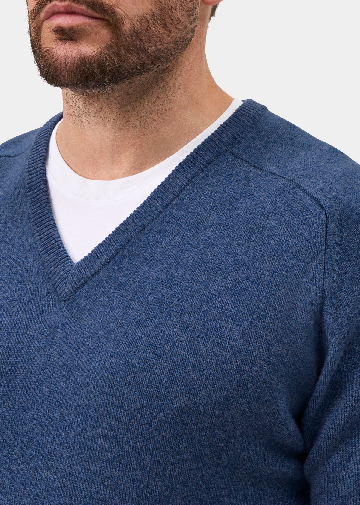 Bearded man in Kilsyth Lambswool Vee Neck Jumper in Jeans, layered over white tee—shoulders up.