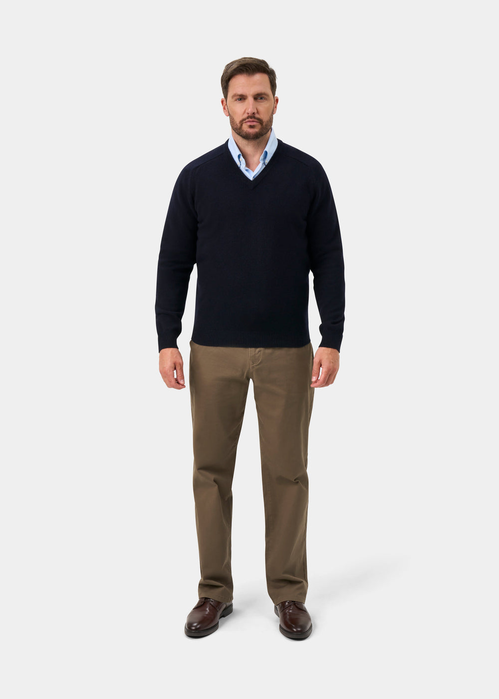 Man in khaki pants, blue shirt, brown shoes, and Kilsyth Lambswool V-Neck Jumper in Navy against a white background.