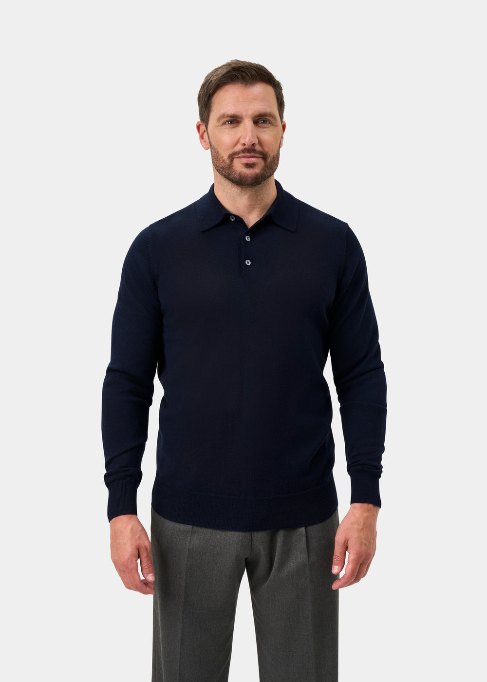 A man with brown hair and a beard wears the Hindhead Men’s Merino Wool Polo Shirt in Dark Navy - Regular Fit.