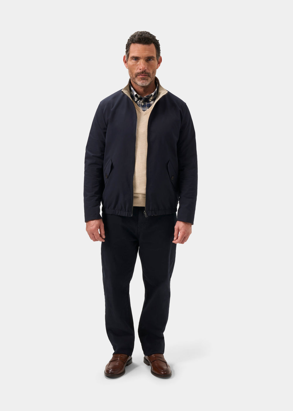 Man in Lakeward Men’s Reversible Bomber Jacket in navy and beige stands against a plain background.