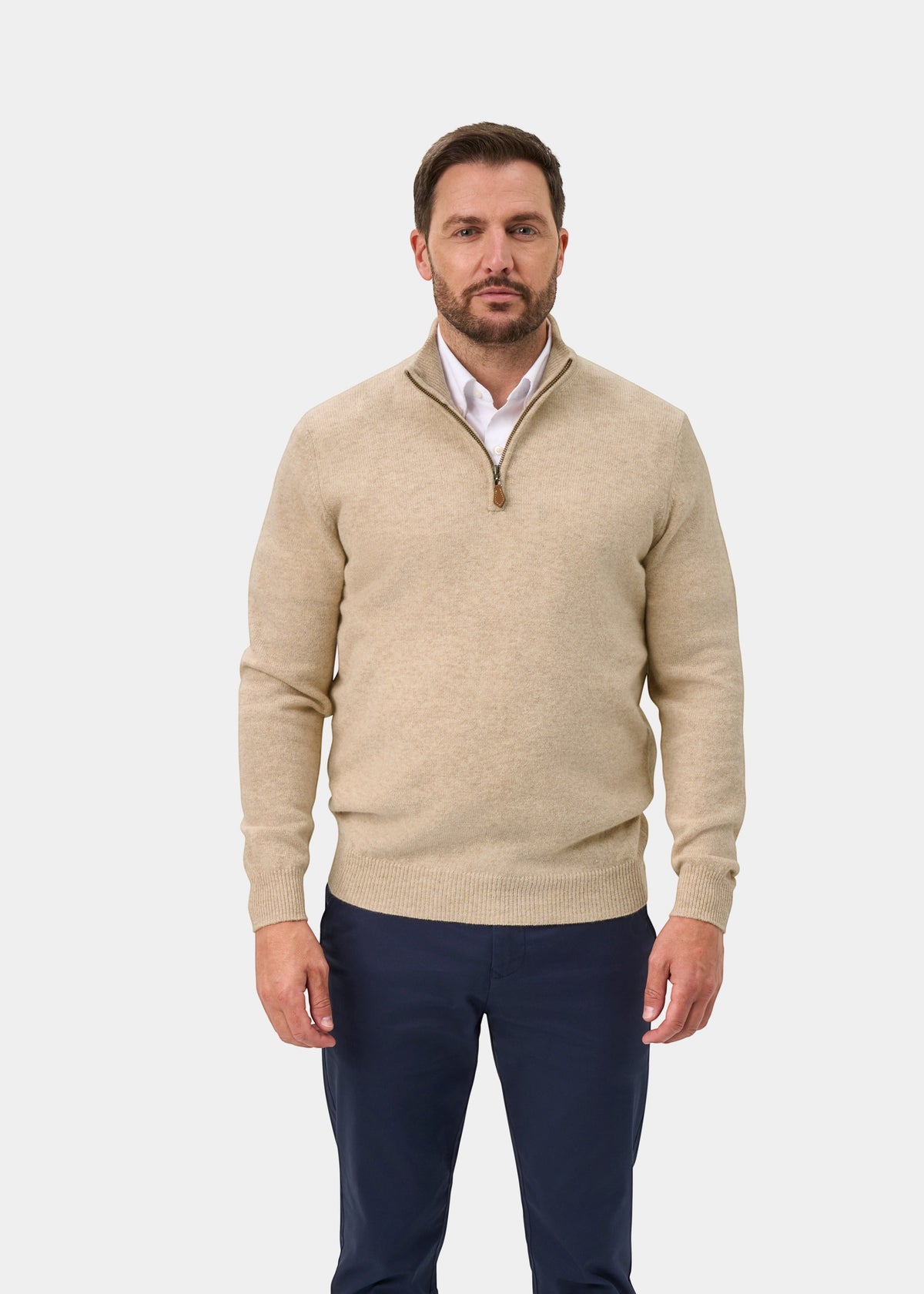 A man wearing a Sutherland Lambswool Quarter Zip Jumper In Linen over a white collared shirt and dark trousers.