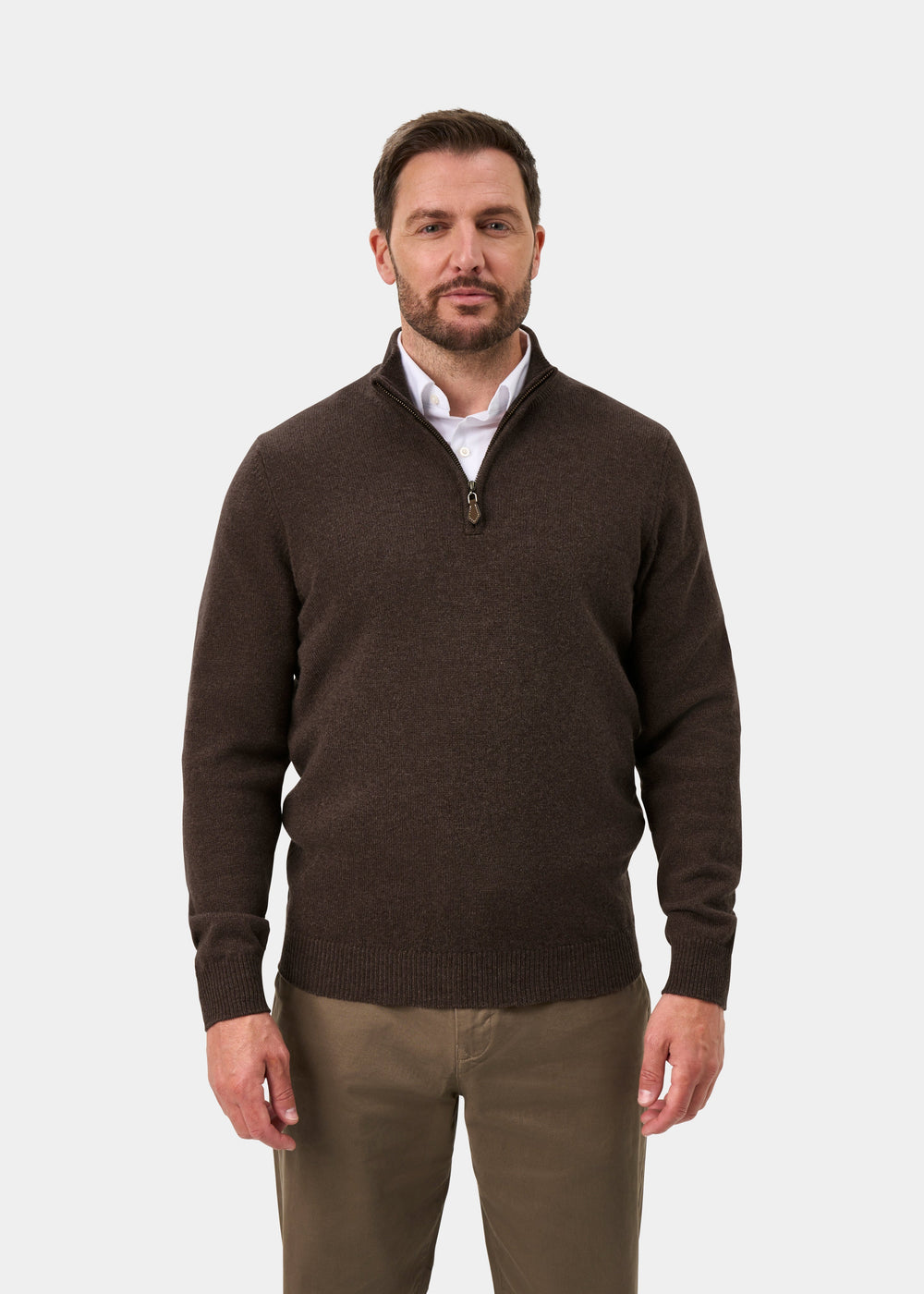 A man wearing a Sutherland Lambswool Quarter Zip Jumper In Mocha over a white collared shirt and khaki trousers.